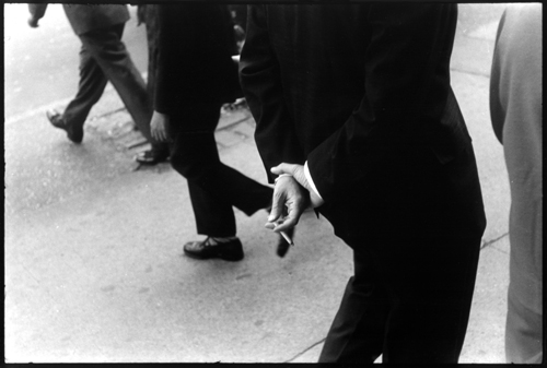 man in a suit holding cigarette 